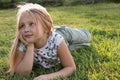 Girl in a summer park lies on the grass