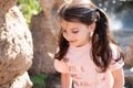 Little beautiful girl with pigtails smiling on the background of a stone wall