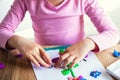 Little beautiful girl in pink headphones listens to music and does creative work, sculpts with plasticine,.close up hands Royalty Free Stock Photo