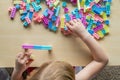 Small preschooler girl playing with colorful toy building blocks, sitting at the table Royalty Free Stock Photo