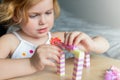 Small preschooler girl playing with colorful toy building blocks, sitting at the table Royalty Free Stock Photo