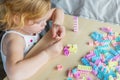 Small preschooler girl playing with colorful toy building blocks, sitting at the table Royalty Free Stock Photo