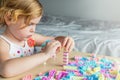 Small preschooler girl playing with colorful toy building blocks, sitting at the table Royalty Free Stock Photo