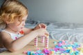 Small preschooler girl playing with colorful toy building blocks, sitting at the table Royalty Free Stock Photo