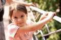 Little beautiful girl with a ponytail leans on the handrail Royalty Free Stock Photo