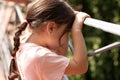 Little beautiful girl with a ponytail leans on the handrail Royalty Free Stock Photo
