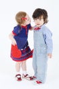Little beautiful girl with red heart prepares to kiss boy Royalty Free Stock Photo