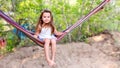 Little beautiful girl sitting in a hammock and smiling Royalty Free Stock Photo