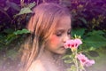 Little beautiful girl smelling a flower