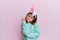 Little beautiful girl wearing cute easter bunny ears with a big smile on face, pointing with hand and finger to the side looking Royalty Free Stock Photo