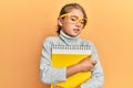 Little beautiful girl wearing glasses and holding books clueless and confused expression Royalty Free Stock Photo