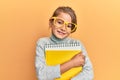 Little beautiful girl wearing glasses and holding books smiling with a happy and cool smile on face Royalty Free Stock Photo