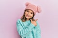 Little beautiful girl wearing wool sweater and cute winter hat smiling cheerful pointing with hand and finger up to the side Royalty Free Stock Photo