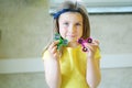 Little beautiful girl in yellow t-shirt is playing with two spinners in hands