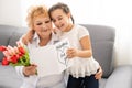 Little beautiful granddaughter gives her grandmother a bouquet of pink tulips. The concept of family, respect Royalty Free Stock Photo