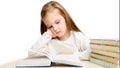 Little beautiful preschooler girl sitting at the table reads books, tired and sad on a white background Royalty Free Stock Photo