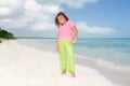 Little beautiful pretty fashionable girl standing on Cuban beach against turquoise ocean and blue sky background Royalty Free Stock Photo