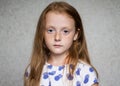 Little beautiful red-haired girl with freckles looking seriously Royalty Free Stock Photo