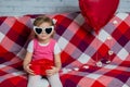 Little beautiful sad girl with red gift box heart and balloon. Dull Valentine`s Day celebration. I`m not in mood for holiday. Royalty Free Stock Photo