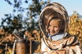 Little beekeeper blows smoker for bees Royalty Free Stock Photo