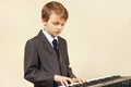 Little beginner musician in a suit playing electronic synth Royalty Free Stock Photo
