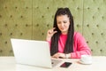 Little bit! Portrait of attractive young girl with black dreadlocks hairstyle are sitting in cafe, working and making video call Royalty Free Stock Photo