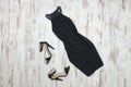 Little black dress and shoes. Wooden background, fashionable con Royalty Free Stock Photo