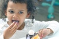 Little black girl eating a cake.. dessert food