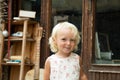 Little blond blue eye girl in white dress with pink flowers portrait. Tricky funny child. Retro style picture. Vintage Royalty Free Stock Photo