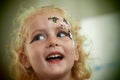 Little blond blue eyed girl face painting is smiling Royalty Free Stock Photo