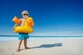 Little blond boy on the beach with inflatable yellow duck buoy Royalty Free Stock Photo