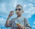 Little Blond Boy Blowing Out Bubbles At Park. Concept of Happy Family And Childhood Royalty Free Stock Photo