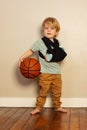 Little blond boy with broken hand holding basketball ball Royalty Free Stock Photo