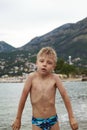 little blond boy came out of the sea to the shore, was cold and