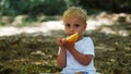 Little blond boy eating melon in nature Royalty Free Stock Photo