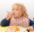 Little blond boy eating pasta with tomato sauce Royalty Free Stock Photo