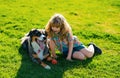 Little blond boy with her pet dog outdooors in park. Child with pet puppy dog. A child with a dog playing in nature on