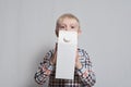 Little blond boy is holding a big white carton package. Light background Royalty Free Stock Photo