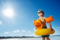 Little blond boy with inflatable yellow duck on ocean sand beach Royalty Free Stock Photo