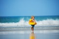 Little blond boy with inflatable yellow duck over sea waves Royalty Free Stock Photo