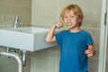 Little blond boy learning brushing his teeth in domestic bath. K Royalty Free Stock Photo