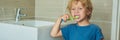 Little blond boy learning brushing his teeth in domestic bath. Kid learning how to stay healthy. Health care concept BANNER, long Royalty Free Stock Photo