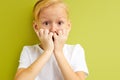 little blond boy looking into camera with wow expression indoors, studio portrait Royalty Free Stock Photo