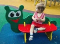 Little blond boy looking expectantly the side sitting on brightly colored bench Royalty Free Stock Photo