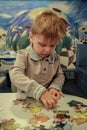 Little blond boy makes a picture from the puzzle.