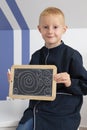 Little blond boy sitting with a chalk slate Royalty Free Stock Photo