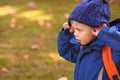 Little blond boy wearing warm blue hat and blue