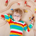 Little blond child playing with wooden railroad trains indoor Royalty Free Stock Photo