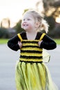 Little blond girl in bee costume dancing outdoors Royalty Free Stock Photo
