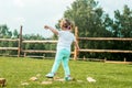 Little blond girl climbing over the wooden fence, summer day on the forest background. Vocation in the village Royalty Free Stock Photo